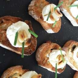 Tartine, fromage de chèvre, miel, pignons de pain et ciboulette